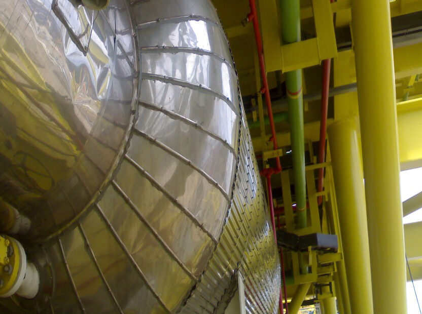 Construction site featuring corrugated cladding with three pipe sizes using hot insulation.